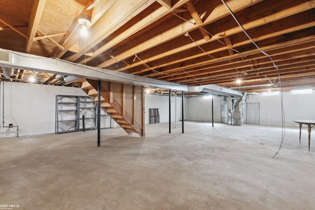 unfinished basement with heating unit and stairs