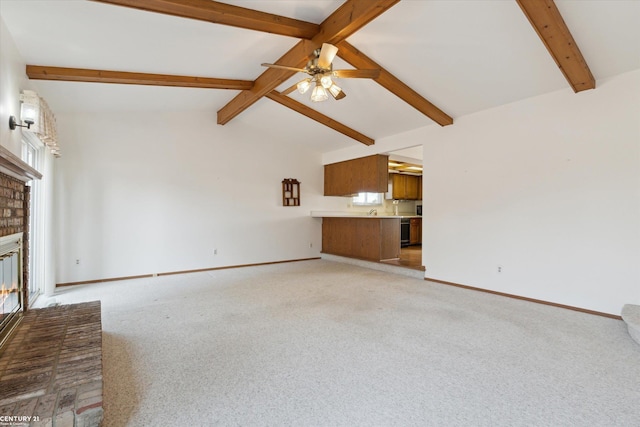 unfurnished living room with a ceiling fan, a fireplace, baseboards, light colored carpet, and vaulted ceiling with beams