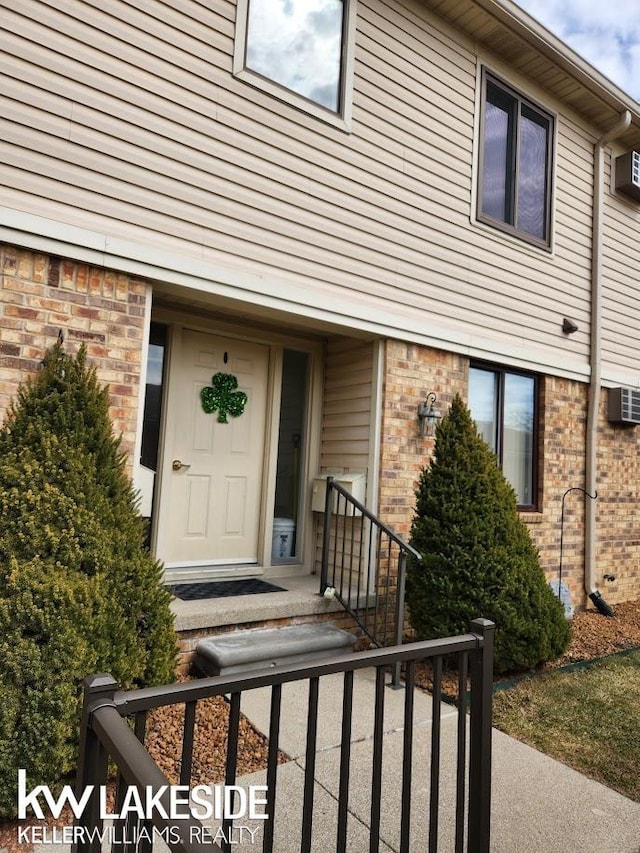 view of exterior entry with brick siding