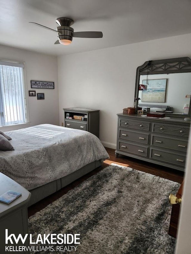 bedroom featuring baseboards, dark wood-type flooring, and a ceiling fan