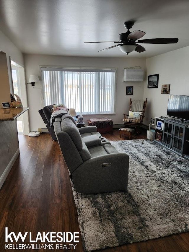 living area with baseboards, ceiling fan, and wood finished floors