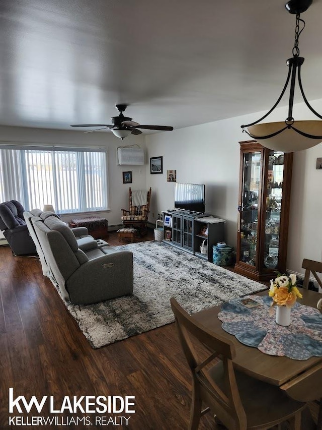 living room featuring wood finished floors, a ceiling fan, and a wall unit AC