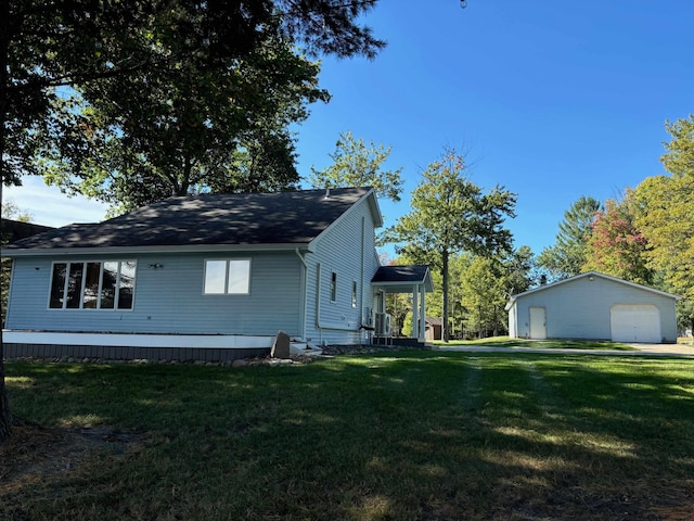 view of side of property featuring a garage, a lawn, and an outdoor structure