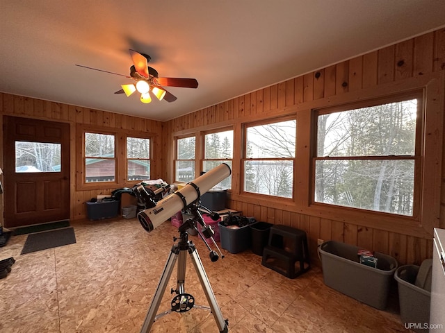 workout area featuring wooden walls and a ceiling fan