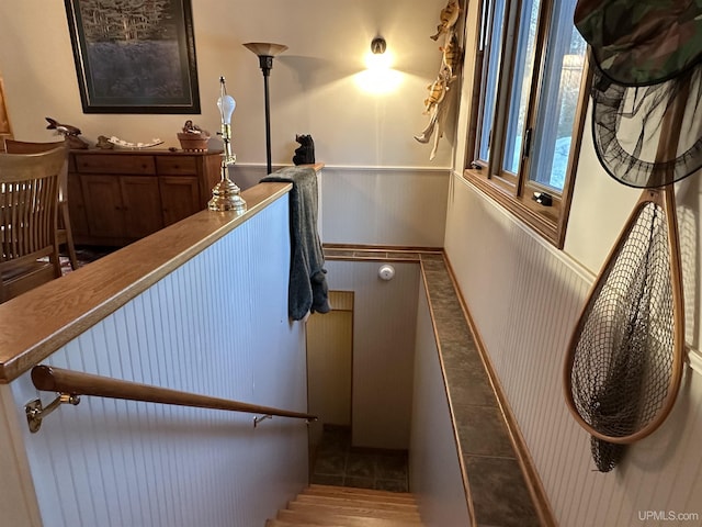 stairway featuring tile patterned floors and wainscoting