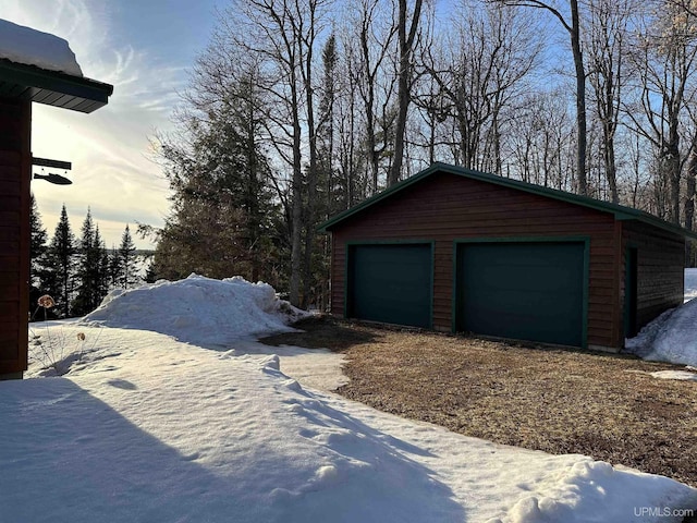 snow covered garage featuring a garage