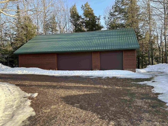 snow covered garage featuring a detached garage