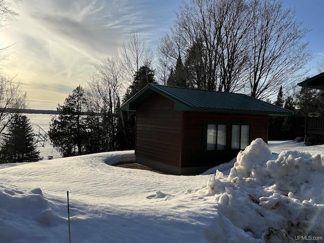 snow covered structure featuring an outdoor structure