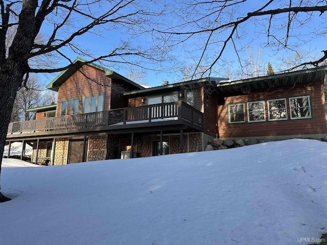 exterior space featuring stone siding and a wooden deck