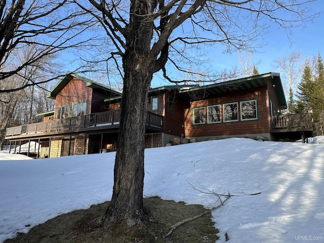 view of snow covered exterior featuring a wooden deck