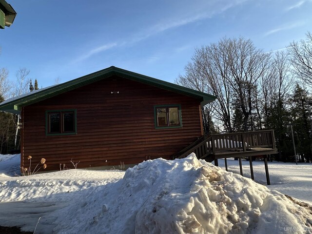 view of snow covered exterior with a deck