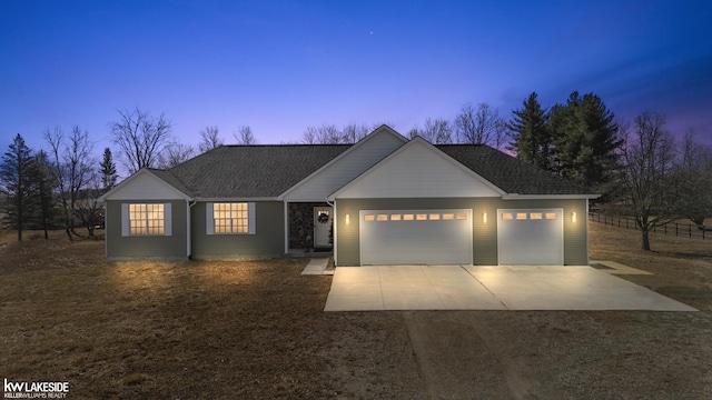 ranch-style home featuring a garage, driveway, and a shingled roof