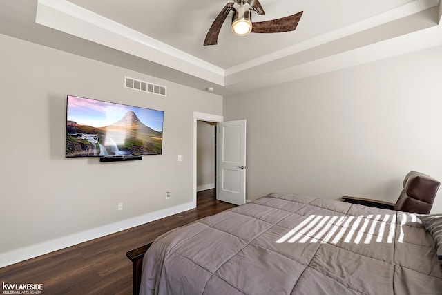 bedroom featuring baseboards, visible vents, ceiling fan, dark wood-type flooring, and a raised ceiling