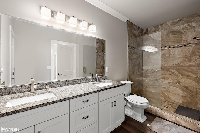 full bath featuring wood finished floors, tiled shower, and a sink