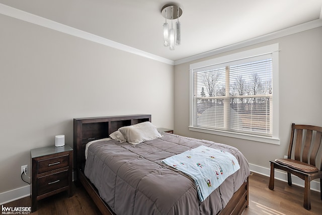 bedroom with crown molding, wood finished floors, and baseboards