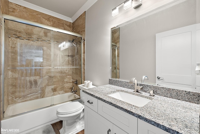 bathroom with combined bath / shower with glass door, toilet, and vanity