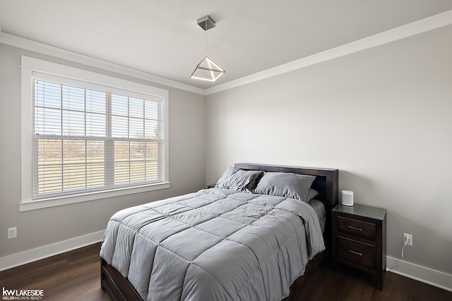 bedroom featuring baseboards, dark wood-style flooring, and crown molding