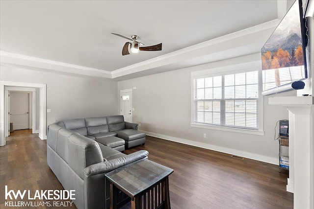 living room with visible vents, a raised ceiling, a ceiling fan, and wood finished floors