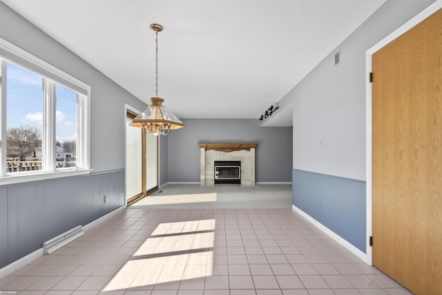 interior space with tile patterned flooring, visible vents, baseboards, a chandelier, and a premium fireplace