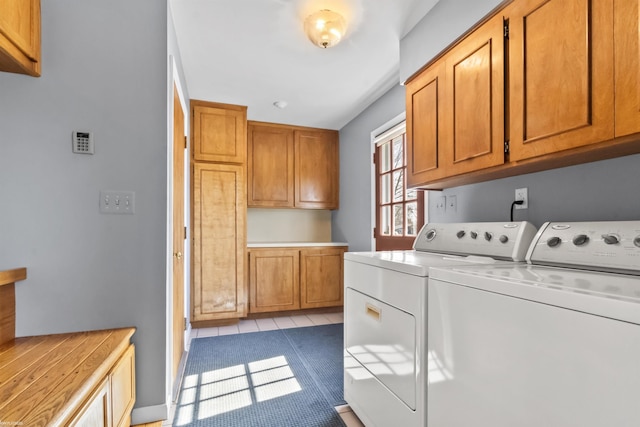 laundry area with light tile patterned floors, cabinet space, and separate washer and dryer