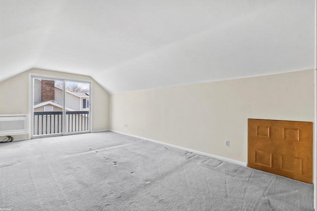 additional living space featuring vaulted ceiling, carpet, and baseboards