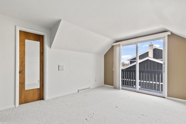 additional living space with visible vents, carpet floors, baseboards, and vaulted ceiling