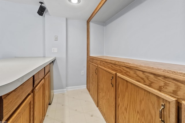 interior space with baseboards and light floors