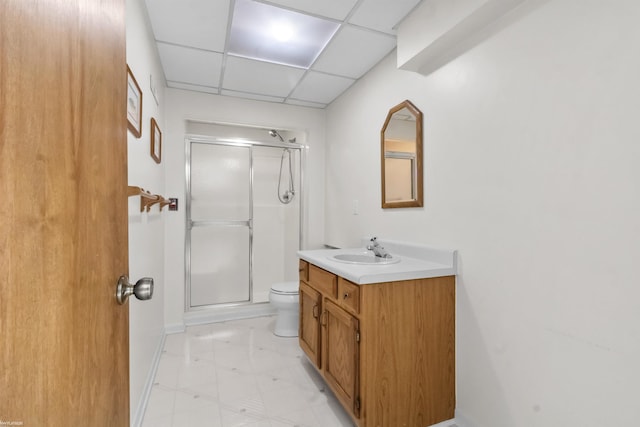 bathroom with vanity, a stall shower, a paneled ceiling, tile patterned floors, and toilet