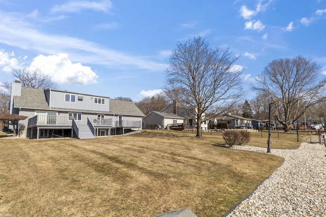 view of yard with a wooden deck, stairs, and fence