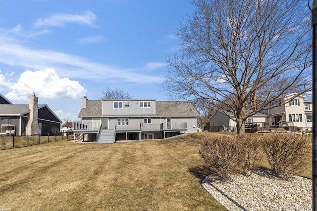 rear view of house with a yard, a fenced backyard, roof with shingles, and a wooden deck