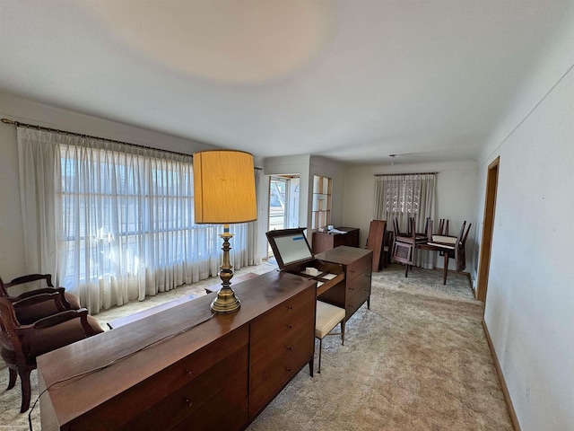 office space with baseboards and light colored carpet