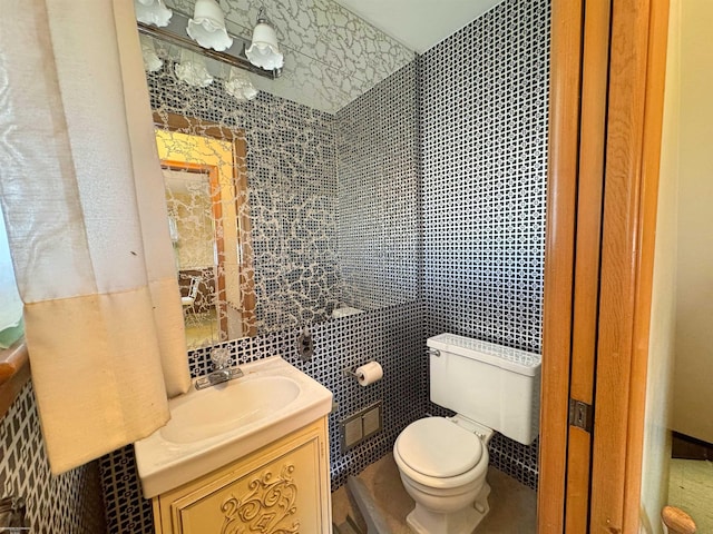 bathroom with vanity, tile walls, and toilet