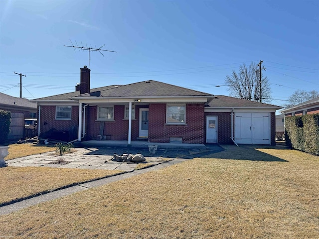 single story home featuring brick siding, an attached garage, a chimney, and a front yard