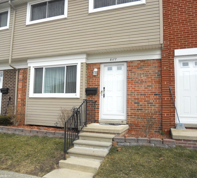 view of exterior entry with brick siding