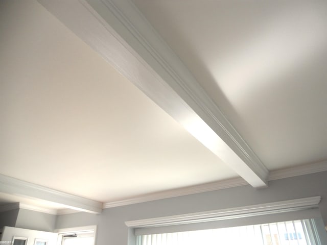 details featuring beamed ceiling and crown molding