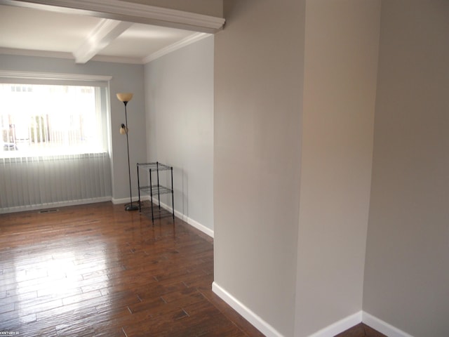 spare room featuring beamed ceiling, wood finished floors, baseboards, and ornamental molding