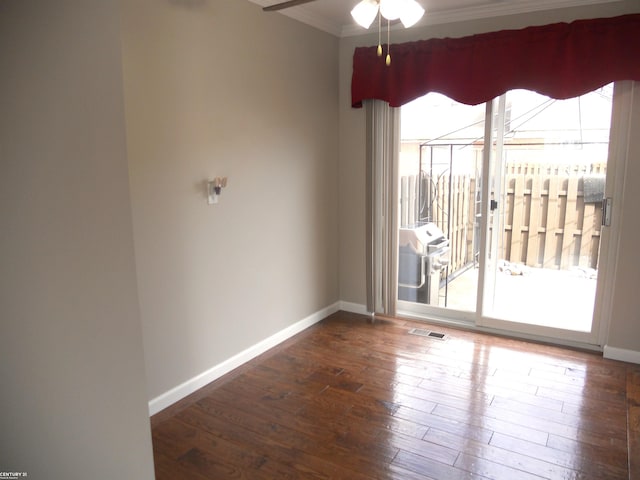 spare room featuring a wealth of natural light, visible vents, ceiling fan, and hardwood / wood-style flooring