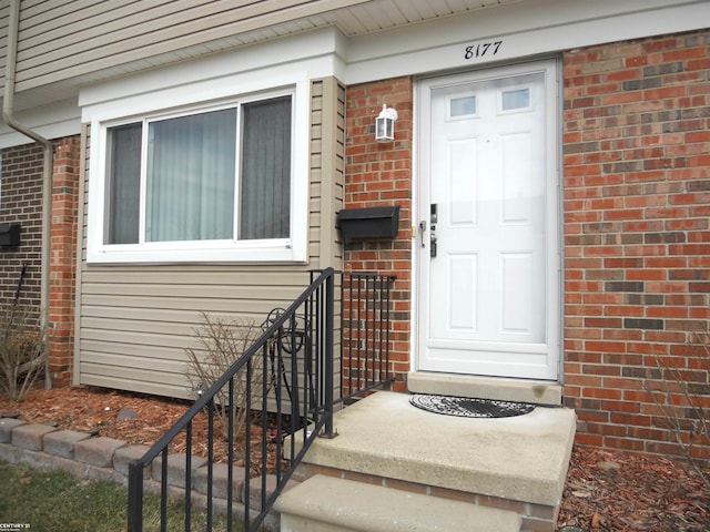 doorway to property with brick siding