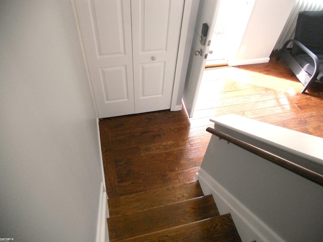 stairway featuring baseboards and wood-type flooring