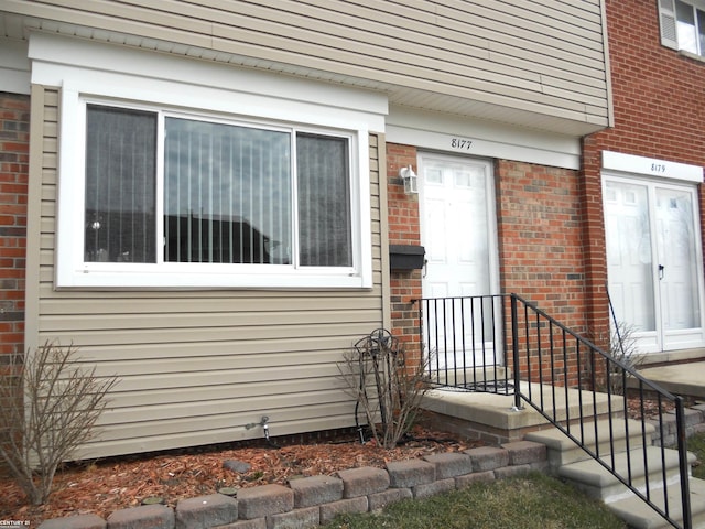 view of exterior entry featuring brick siding