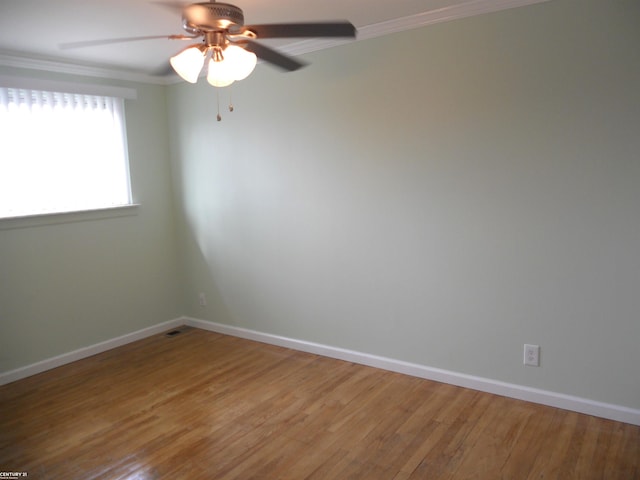 spare room featuring ornamental molding, baseboards, ceiling fan, and wood finished floors