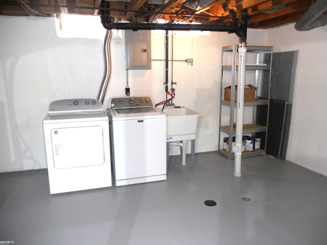 unfinished basement featuring a sink, electric panel, and washing machine and dryer