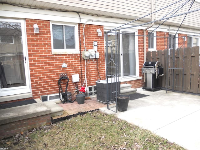 view of patio / terrace featuring cooling unit, entry steps, area for grilling, and fence