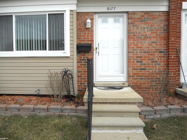 doorway to property with brick siding