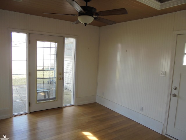 interior space featuring ceiling fan, baseboards, and wood finished floors