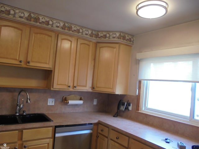 kitchen featuring dishwasher, light countertops, tasteful backsplash, and a sink