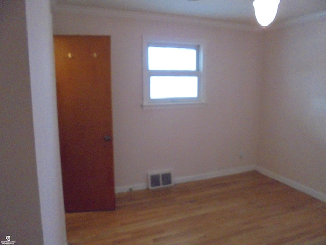 empty room featuring baseboards, visible vents, and light wood finished floors