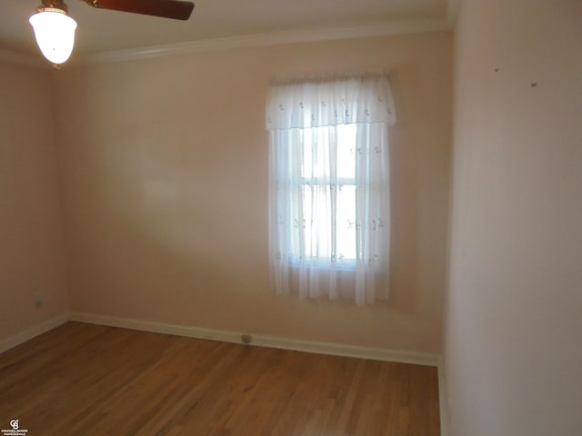 unfurnished room featuring ceiling fan, baseboards, wood finished floors, and crown molding