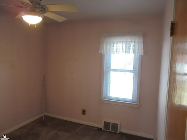 unfurnished room with baseboards, visible vents, and ceiling fan