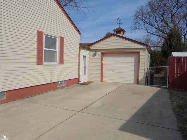 garage featuring driveway and fence